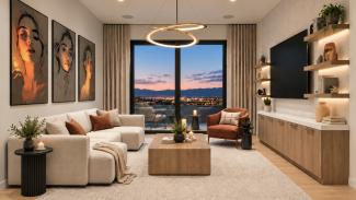 Living room with a sectional sofa, ring chandelier and a wall of glass framing mountain views at dusk